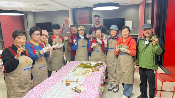 SOPMCA volunteers holding handmade zongzi at Wentworth Point Library